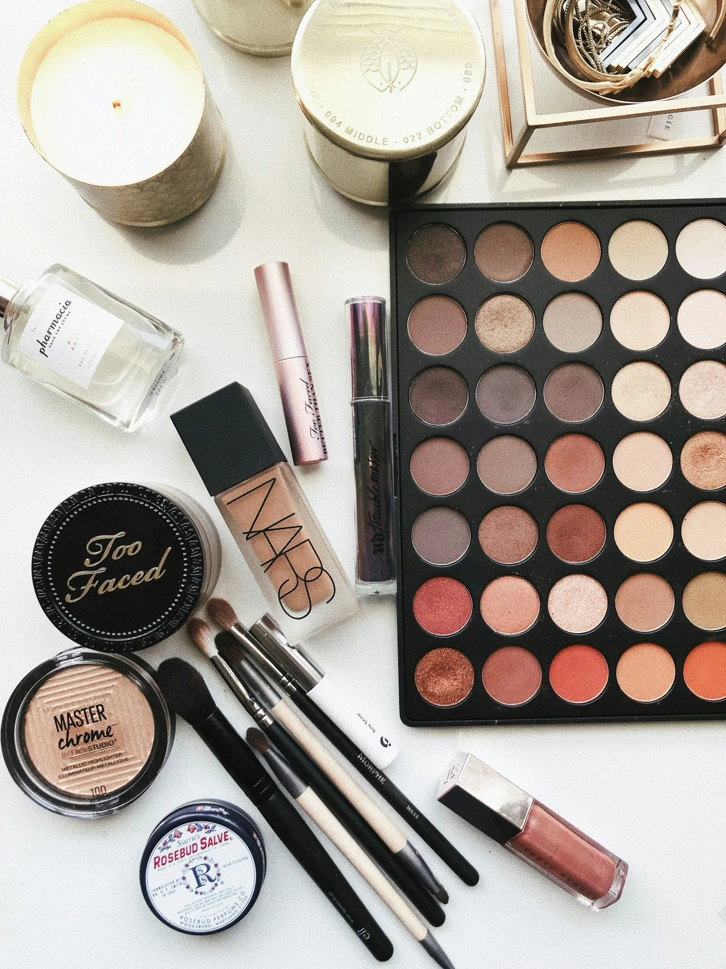 Makeup palettes, powder compacts, and brushes viewed from above
